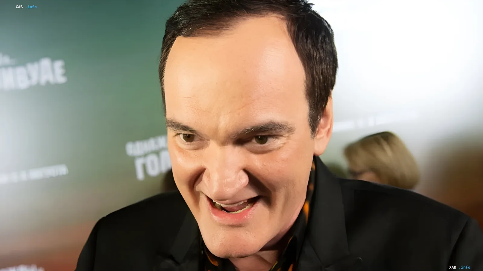 Quentin Tarantino smiling during a public appearance at his film presentation