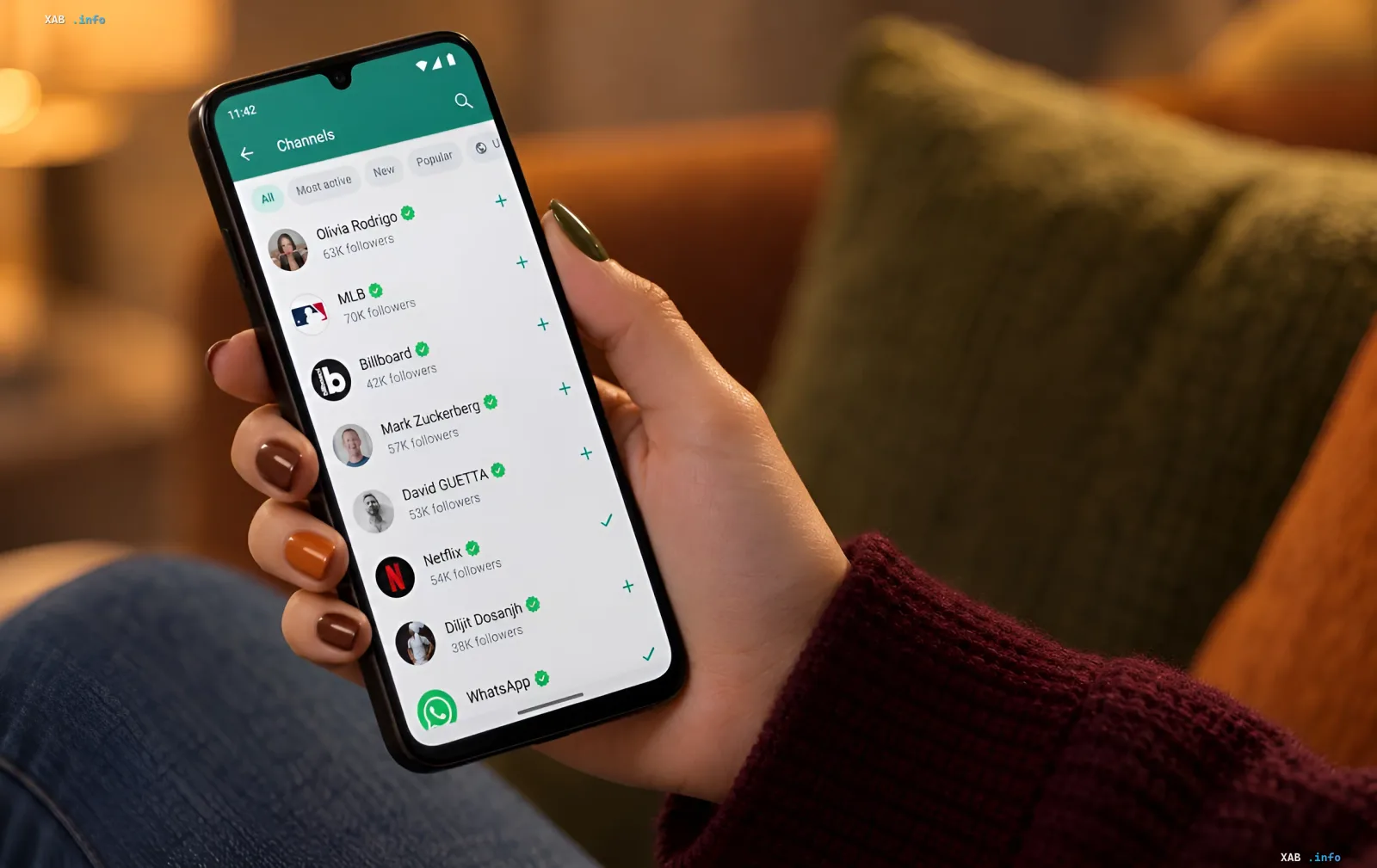 Eine Person hält ein Smartphone in den Händen, auf dem der Channels-Bereich des WhatsApp-Messengers angezeigt wird