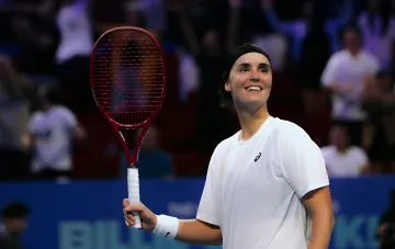 Angelina Kalinina joyfully holding a tennis racket on the court after a successful season