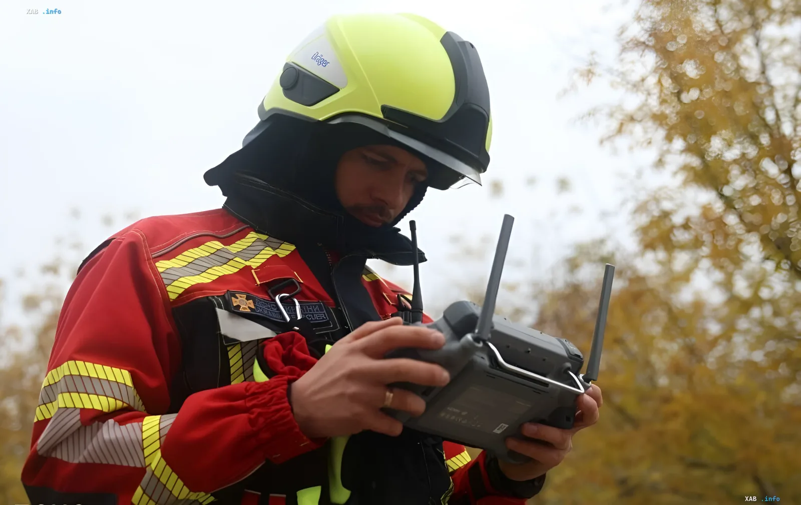 Rescuer in protective helmet and uniform operating a drone outdoors