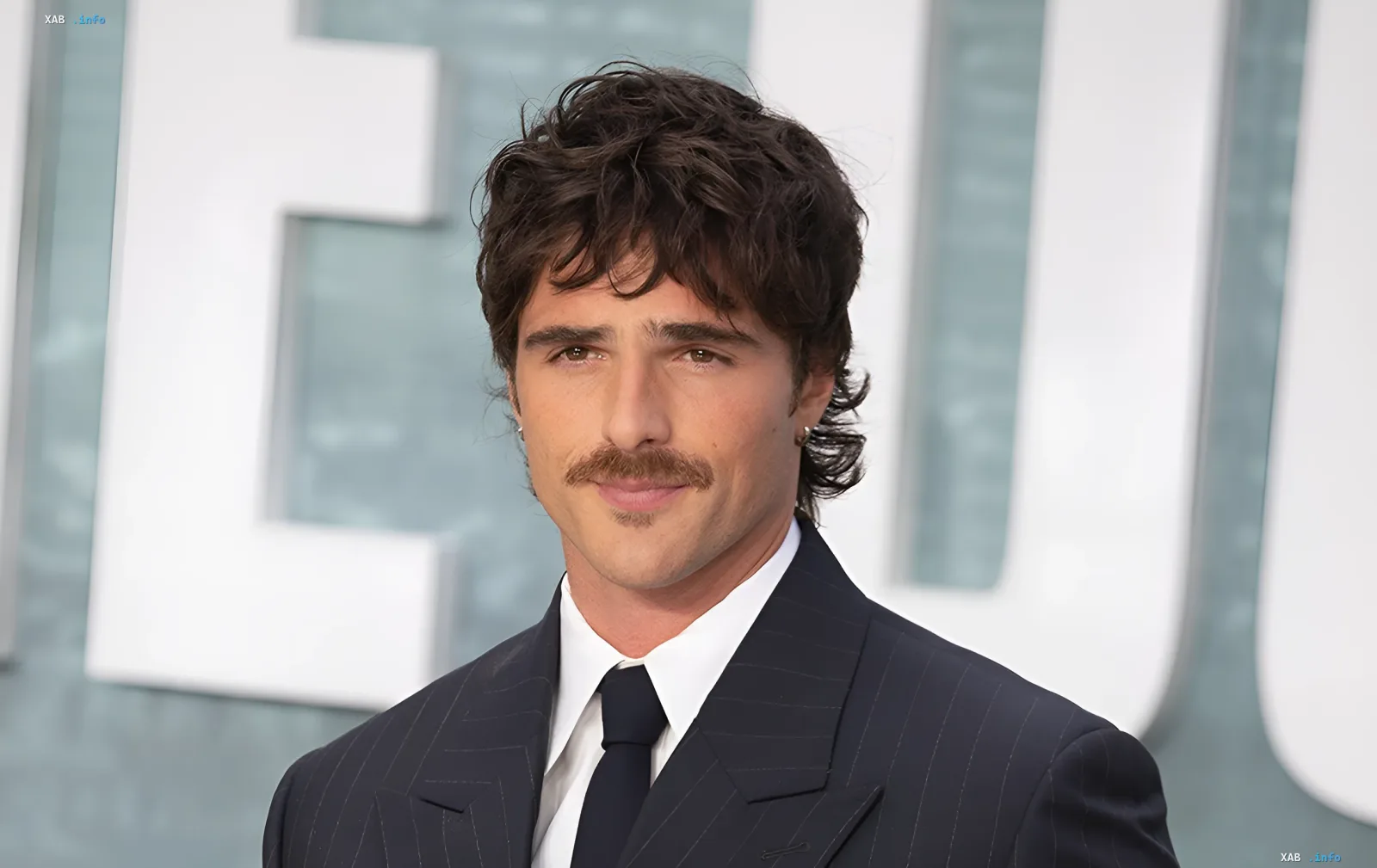 Australian actor Jacob Elordi wearing a mustache and a dark suit at an event
