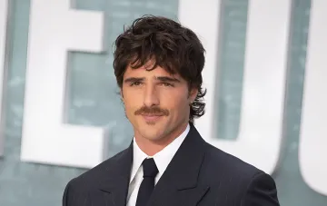 Australian actor Jacob Elordi wearing a mustache and a dark suit at an event