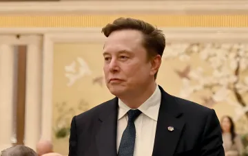 Elon Musk in a formal suit at an official event