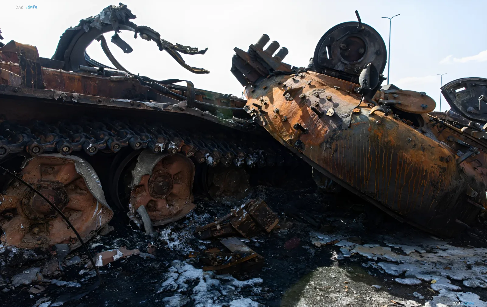 Burned Russian armored vehicles and a destroyed tank on a ruined road after battles
