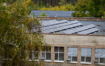 Solar panels on the roof of a social nursing home in Kyiv surrounded by trees