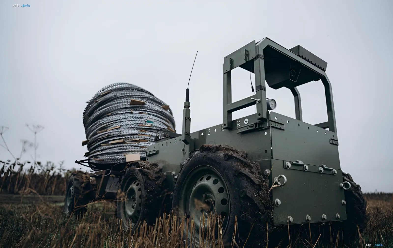 Ground military robot with a barbed wire coil on the battlefield