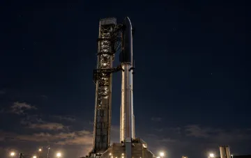 Super-heavy Starship rocket on the launch pad at night under a starry sky before a test launch