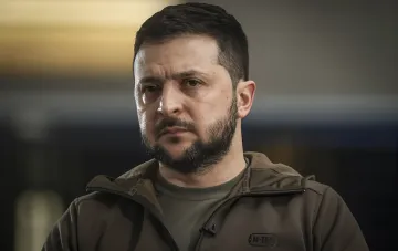 Ukrainian President Volodymyr Zelenskyy in a tactical jacket giving an interview while discussing freezing combat operations.