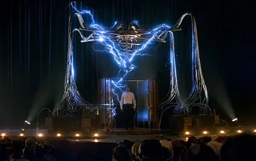 Ein künstlerischer Auftritt eines Illusionisten auf einer Theaterbühne mit elektrischen Entladungen