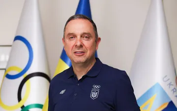 NOC of Ukraine President Vadym Guttsayt stands against the background of national flags