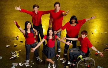 Schauspieler der beliebten Musikserie Glee in roter Kleidung posieren am Set