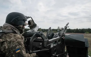 Украинский военнослужащий управляет зенитным орудием для отражения воздушных атак
