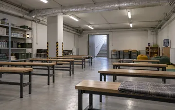 Renovierter und ausgestatteter Kellerschutzraum in einer Schule mit Bänken und Vorräten