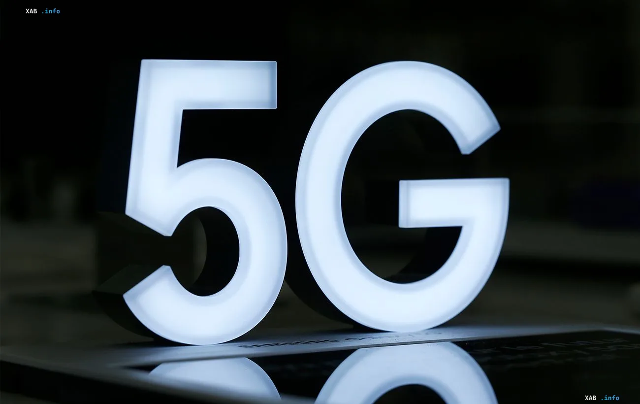 Светящийся белый знак 5G на темном фоне демонстрирует развитие мобильных технологий связи