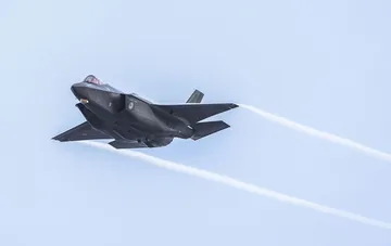 Modern fifth-generation multirole fighter F-35 in flight with vapor trails visible behind the aircraft