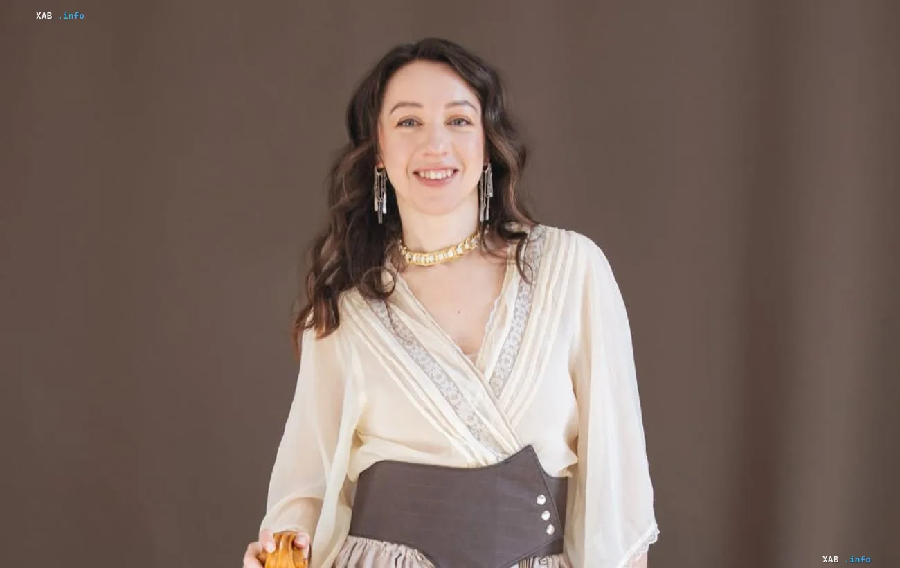 Ukrainian bandurist Anastasiia Voitiuk smiling in a light blouse against a neutral background