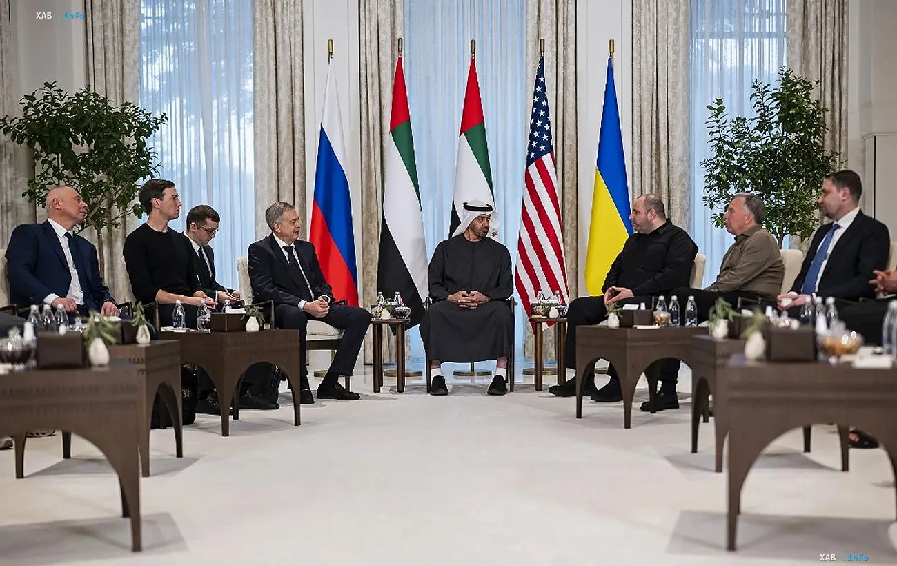 Participants of diplomatic negotiations at a round table with national flags