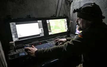 Drohnenoperator an einem Monitor in einem gesicherten Bunker bei der Einsatzkoordinierung