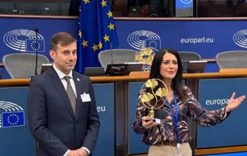 European Parliament Vice-President Pina Picerno holding an award alongside a colleague in the European Parliament hall