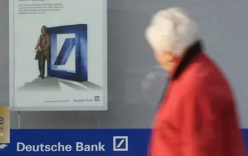 Женщина проходит мимо отделения Deutsche Bank в Германии