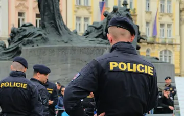 Чеські поліцейські у формі несуть службу на тлі історичного пам'ятника під час акції протесту у Празі