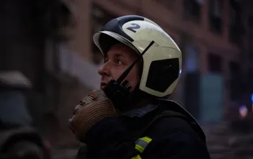 A rescuer in a protective helmet during the elimination of the consequences of an enemy strike in Kharkiv