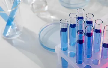 Laborreagenzgläser mit blauer Flüssigkeit im Ständer