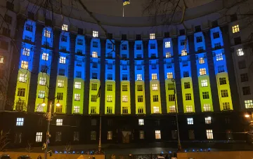 Majestic building of the Ukrainian government illuminated in national flag colors at night