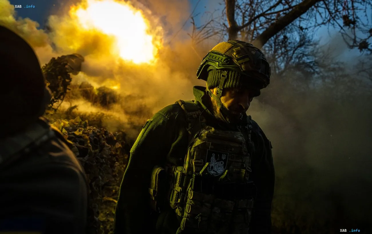 Военнослужащий ВСУ в защитной экипировке на фоне взрыва и дыма на фронте