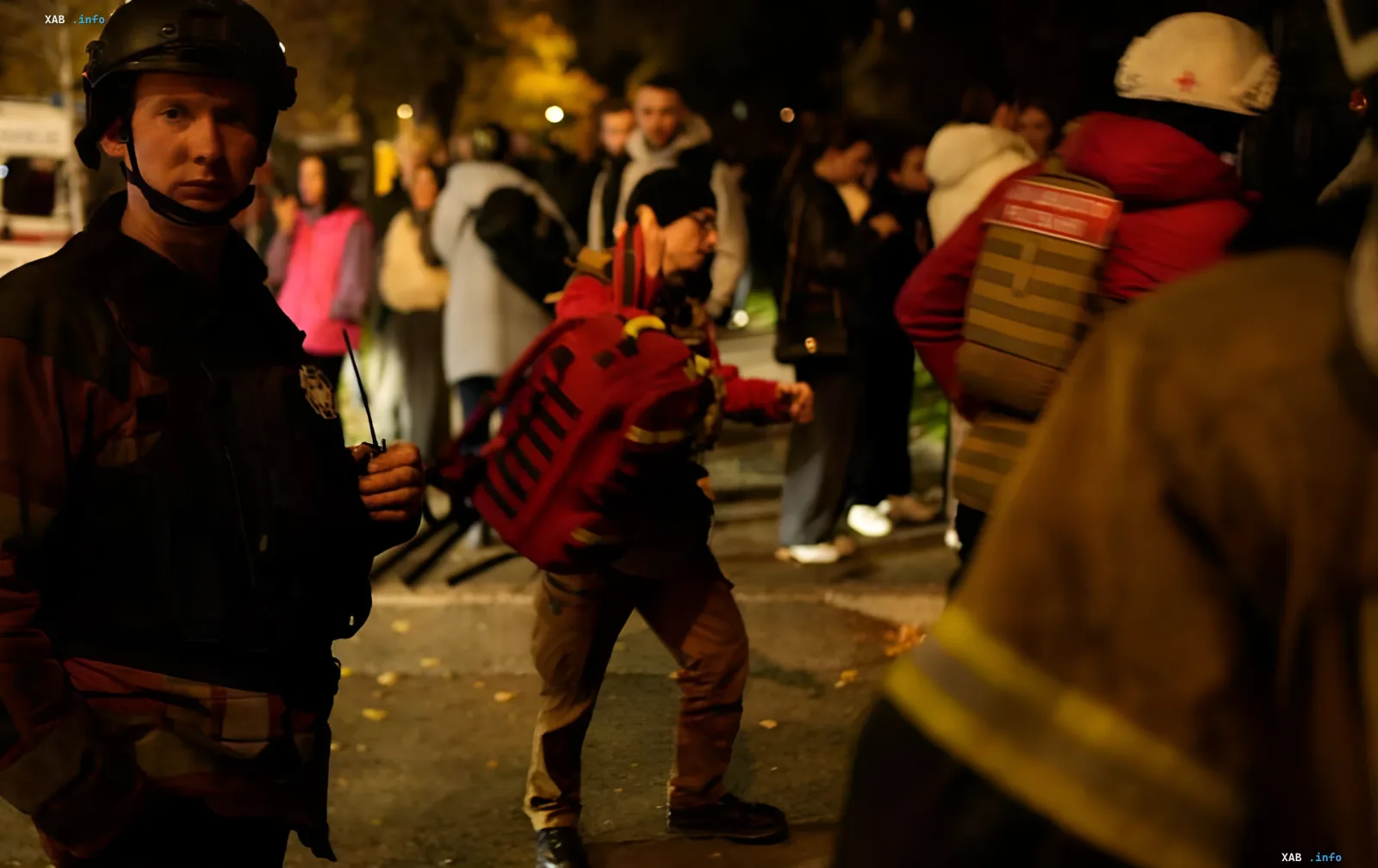 Emergency workers and military personnel at the scene of a nighttime missile strike in Kyiv
