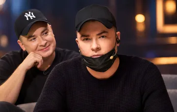 Андрей Данилко в чёрной кепке и маске на подбородке сидит в студии рядом с коллегой