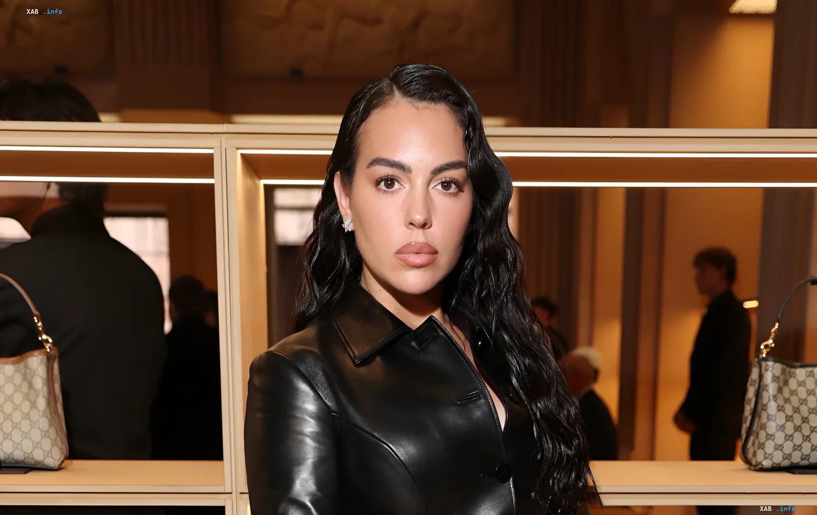 Georgina Rodriguez wearing a black leather jacket in front of shelves with bags during a Calzedonia presentation