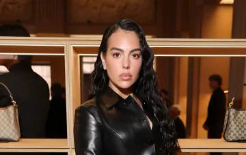 Georgina Rodriguez wearing a black leather jacket in front of shelves with bags during a Calzedonia presentation