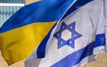 Государственные флаги Украины и Израиля развиваются на ветру на светлом фоне