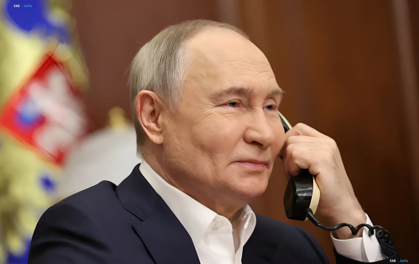 Президент Росії Володимир Путін із посмішкою тримає телефонну трубку в Кремлі