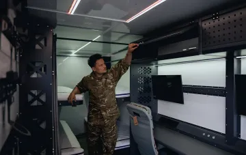 Военный настраивает оборудование внутри мобильного командного пункта малой ПВО