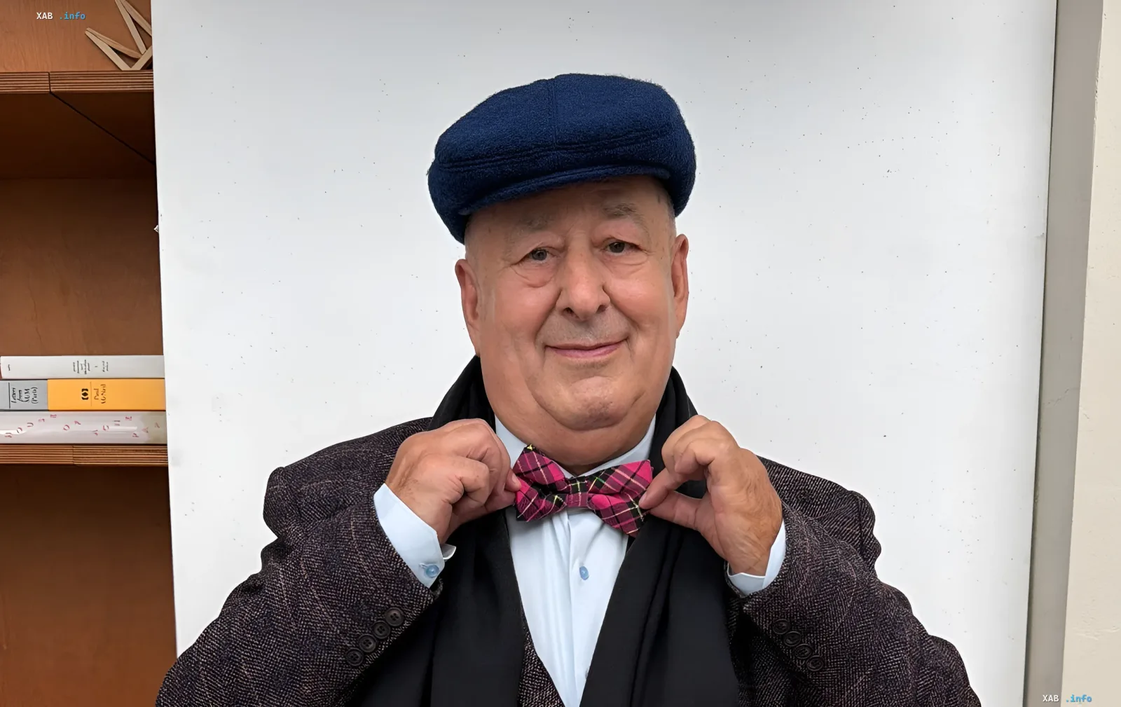 76-year-old Ukrainian TV presenter Mykola Lutsenko wearing a cap and bow tie during a photoshoot