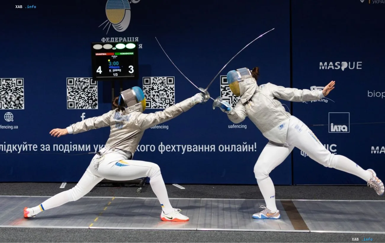 Две спортсменки-саблистки в защитных масках и фехтовальной экипировке соревнуются на дорожке во время Кубка Украины