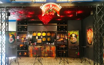 Interieur der Piana Vyshnia Bar mit dunklen Wänden, Kirschdekor und einer Theke