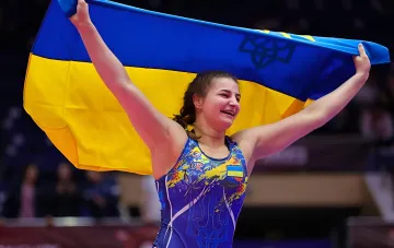 Украинская борчиха Анастасия Алпеева с флагом Украины празднует победу на чемпионате мира