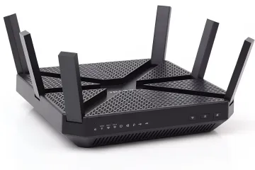 Черный современный маршрутизатор TP-Link с множеством антенн стоит на белом фоне