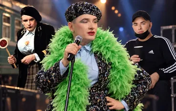 Андрей Данилко в образе Верки Сердючки с перьевым воротником и блестящей береткой на сцене