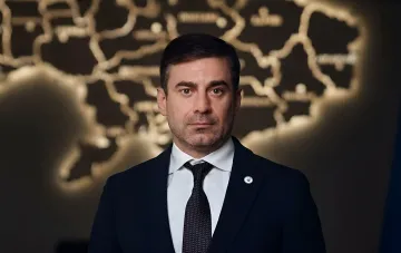 Украинский омбудсман Дмитрий Лубинец на фоне стилизованной карты Украины