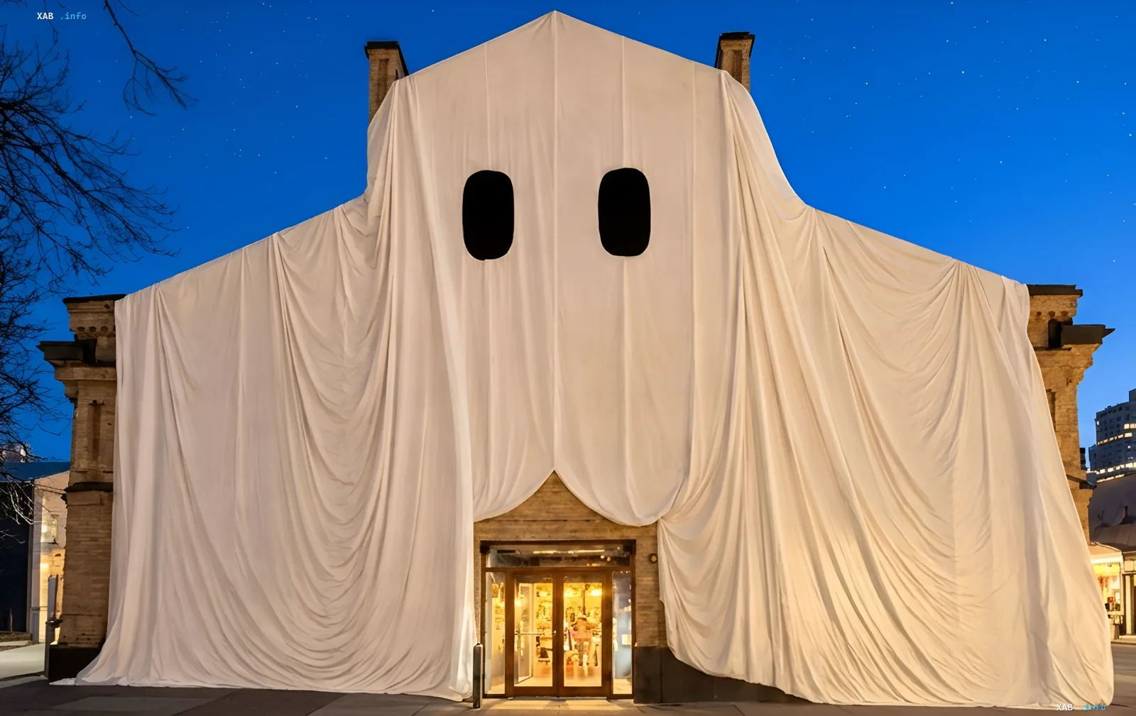 A giant white ghost with dark eyes decorates the facade of Kyiv Food Market for Halloween in evening Kyiv