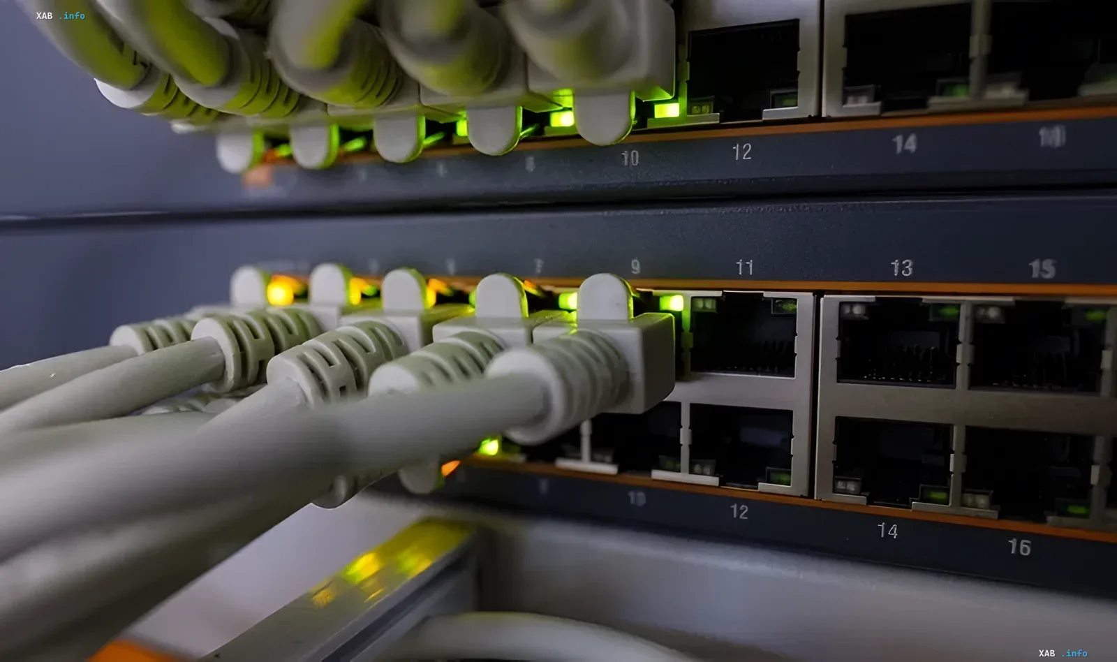 Network switches with connected Ethernet cables and flashing green indicators in a data center rack