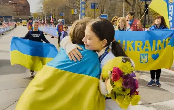 Дети и люди с украинскими флагами обнимаются на улице в знак поддержки и солидарности с Украиной