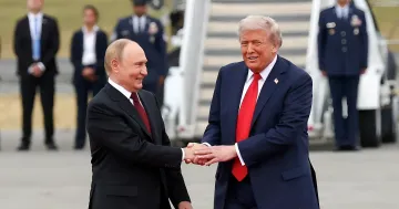 Владимир Путин и Дональд Трамп пожимают друг другу руки во время встречи