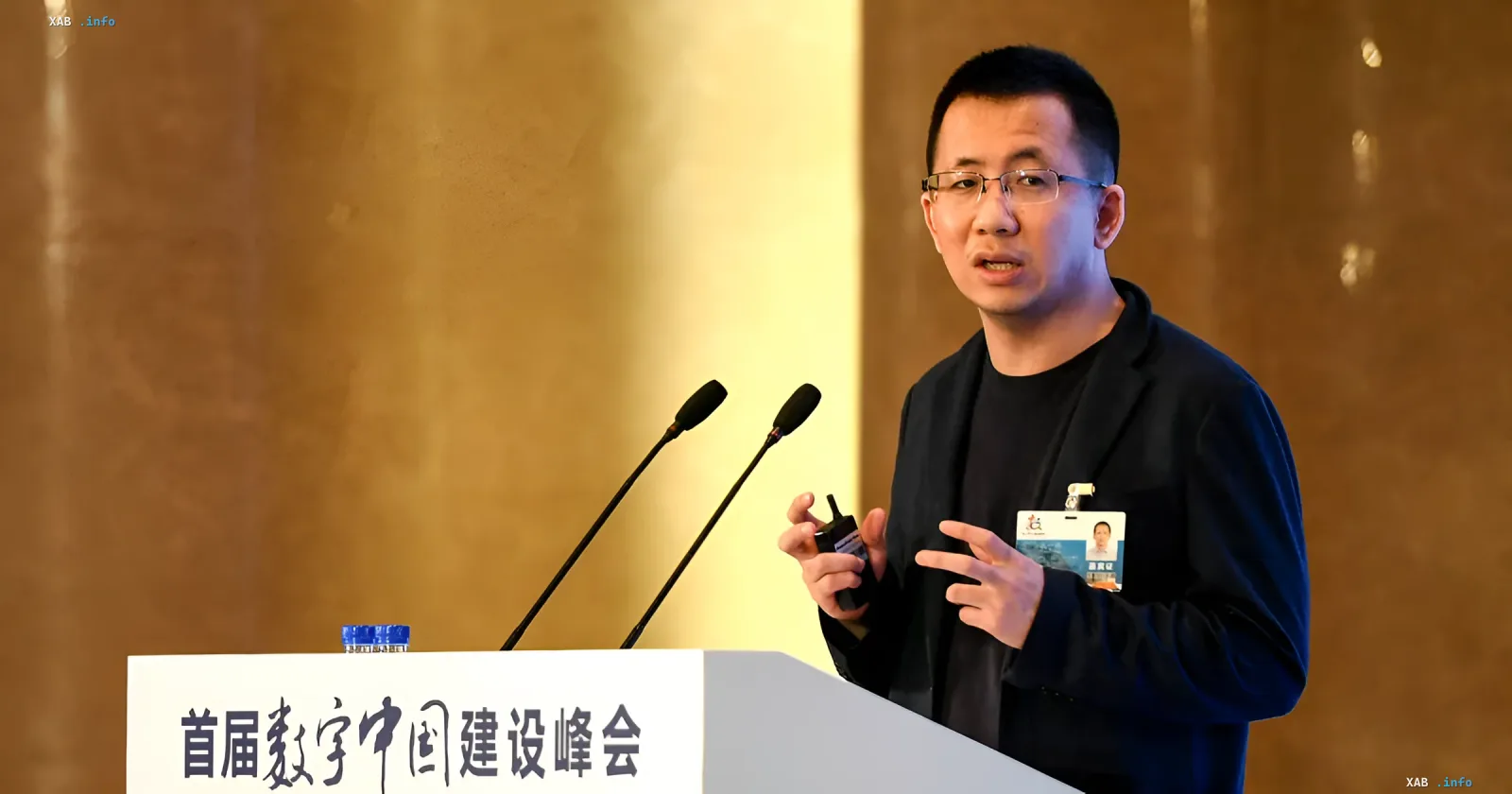 Chinesischer Unternehmer mit Brille spricht an einem Rednerpult auf einem Technologieforum
