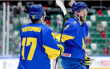 Zwei ukrainische Eishockeyspieler in blau-gelben Trikots auf dem Eis während eines Spiels