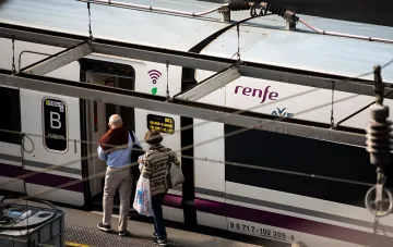 Пассажиры садятся в скоростной поезд Renfe AVE на перроне вокзала